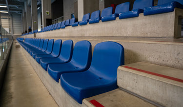 Blauwe kuipstoelen op tribune VAMOS