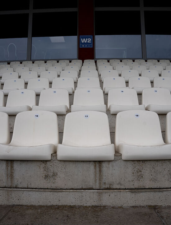 Witte kuipstoelen op tribune met nummering